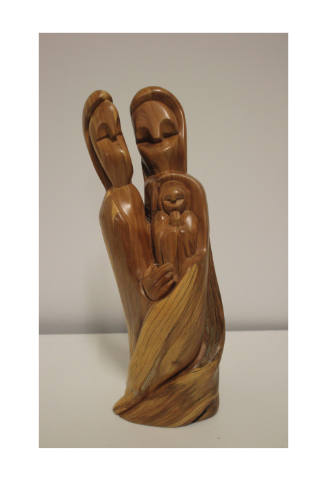 Wooden sculpture of three figures holding each other