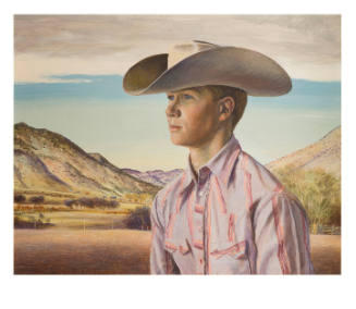 Portrait of a young white man wearing a cowboy hat in front of mountainous landscape.