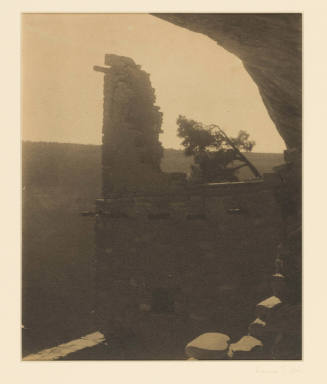Greyscale photograph of a damaged brick cliff dweling overlooking a canyon  