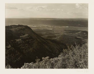 Greyscale photograph looking down on an open landscape with mesas