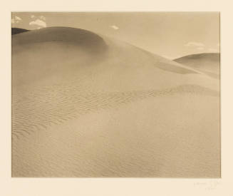 Greyscale photograph of a dune with sky showing in the top fifth of the frame