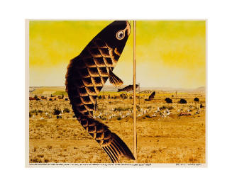 Yellow-tinted photograph of a fish banner with a cemetary in the background