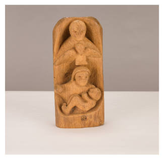 Wooden carving of a person holding a baby above another, separated by a winged figure